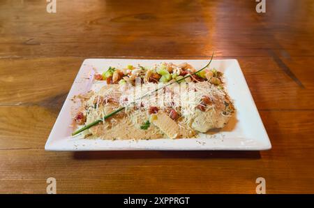 Kurzes Rib-Ravioli-Hauptgericht und Salat auf rustikalem Holztisch Stockfoto