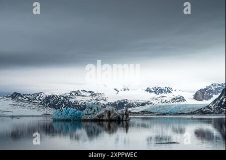 Blick auf schneebedeckte Berge und einen Eisberg im Isfjord, Spitzbergen, Svalbard, Norwegen, Arktis Stockfoto