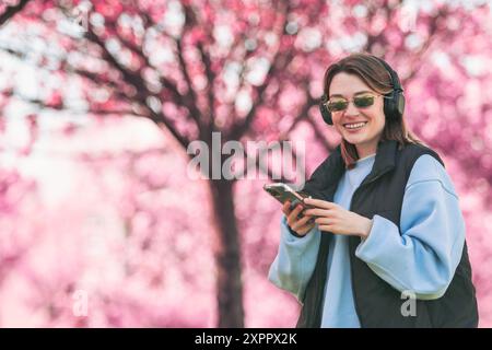 Musikliebhaberin, die Songs auf ihrem Handy überprüft Stockfoto