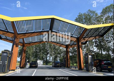 NIEDERLANDE, Fastned Schnellladestation für Elektrofahrzeuge an Tankstelle an der Autobahn, Solarzellen auf Dach / NIEDERLANDE, Fastned Stromladestation für Elektrofahrzeuge an Tankstelle an der Autobahn, Solarzellen auf Dach Stockfoto