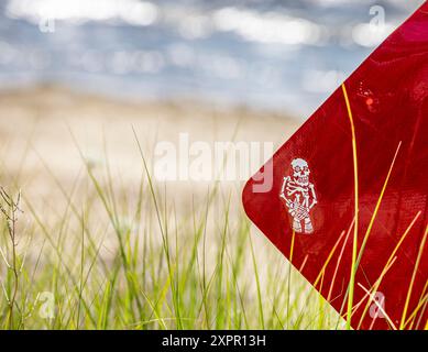 Kleiner weißer Skelett-Aufkleber am Rand eines Verkehrsschilds Stockfoto