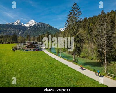 Mann und Frau radeln entlang der Ramsauer Ache auf dem Bodensee-Königssee-Radweg, Watzmann im Hintergrund, Berchtesgaden, Oberbayern, Ba Stockfoto