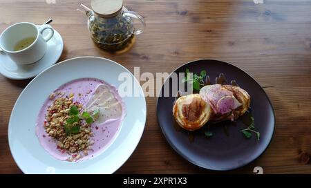 Joghurt- und Müsli-Smoothie mit Birnenstückchen und Pfannkuchen mit Ahornsirup. Stockfoto