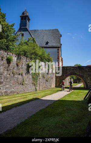 Zwei Personen fahren auf dem Weg im Burggraben von Schloss Steinau, Steinau an der Straße, Spessart-Festland, Hessen, Deutschland Stockfoto