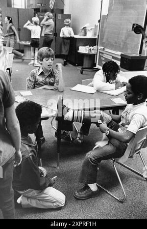 Austin Texas USA, 1984: Der schwarze Schüler Patrick Skeaton, der sein rechtes Bein aufgrund einer Spina bifida verlor, zeigt seine neue Beinprothese einem neugierigen Klassenkameraden. Teil einer erweiterten Fotofunktion. ©Bob Daemmrich Stockfoto