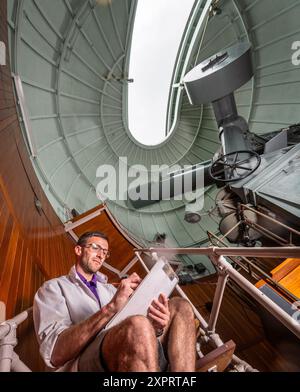 Jack Linsell, Generalassistent, überprüft den Thompson Refractor (gebaut 1896 und in den 1950er Jahren nach Herstmonceux gebracht) in Dome E, im Royal Observatory Science Centre in Herstmonceux, der möglicherweise geschlossen werden muss, weil sein Pachtvertrag für 2026 nicht erneuert wurde. Das Royal Herstmonceux Observatory übernahm das Royal Greenwich Observatory, als es in den 1950er Jahren durch Lichtverschmutzung unmöglich war, Sternenbeobachtungen zu beobachten Heute wird es weitgehend als Bildungszentrum und Museum zur Geschichte der Astronomie genutzt und nimmt jährlich 60.000 Besucher auf. Obwohl sie als Klasse II aufgeführt sind, bauen sie die Teleskope selbst Stockfoto