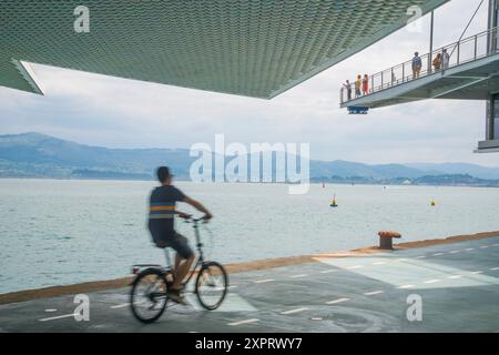 Mann mit dem Fahrrad und Blick auf die Bucht von Botin Center. Santander, Spanien. Stockfoto