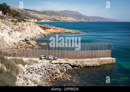 Guardia Zivilbeamte, die Patrouillenwagen einsetzen, um den Umzäunungszaun an der Grenze der Europäischen Union in Melilla, Spanien, mit freiem Blick auf die Küste und das Meer zu überwachen. Foto im Juni 2012. Stockfoto