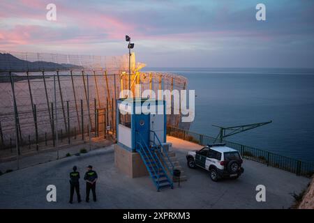 Guardia Zivilbeamte stehen während eines ruhigen Sonnenuntergangs im Juni 2012 an der Außengrenze der Europäischen Union zu Afrika in der spanischen Enklave Melilla an einem Grenzüberwachungsposten. Stockfoto