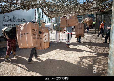 Marokkaner transportierten Waren von Europa nach Afrika zu Fuß am Grenzübergang Melilla im Juni 2012. Ein lokales Logistikunternehmen überwacht den Prozess und hebt den Transport von Verbrauchsmaterial und manueller Arbeit hervor. Stockfoto