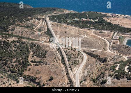 Ein hochauflösendes Luftbild, das den weitläufigen Grenzzaun bei Melilla, einer spanischen Enklave in Afrika, zeigt. Das Bild zeigt die komplizierte Sicherheitseinrichtung mit mehreren Zäunen und Überwachungssystemen vor einer rauen Landschaft. Stockfoto