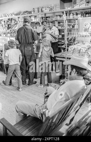 Mazedonien, Arkansas, USA – 23. Juni 2024: Vertikale Aufnahme einer Familie, die 1975 in einem alten Arkansas-Laden Einkäufe tätigt. Stockfoto