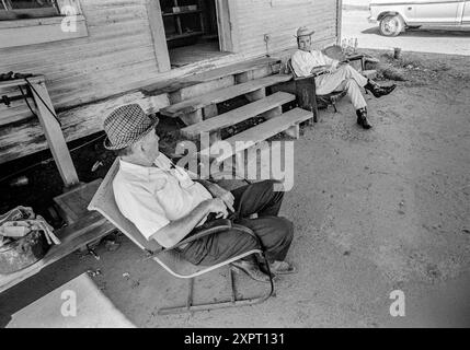 Mazedonien, Arkansas, USA – 23. Juni 2024: Horizontale Aufnahme eines Vaters und Sohnes, die 1975 vor Dads altes Landhaus sitzen. Stockfoto
