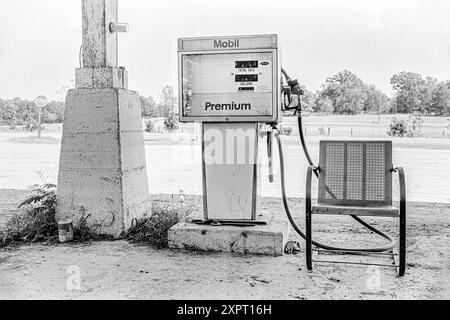 Mazedonien, Arkansas, USA – 23. Juni 2024: Horizontaler Schuss einer alten Mobil-Gaspumpe und eines Vintage-Stuhls in einem alten Arkansas-Laden in 1 Stockfoto