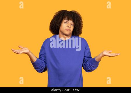 Junge Mit Lockigen Haaren, Die Einen Blauen Pullover Tragen Und Glücklich Zucken Stockfoto