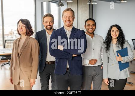 Vielseitiges Business-Team steht in modernen Büroflächen zusammen Stockfoto