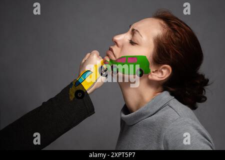 Der Begriff des Autounfalls, Versicherung. Plötzliche Kollisionen von Autos. Das Gesicht der Frau und auf der Faust malte Autos bei einem Zusammenstoß. Stockfoto