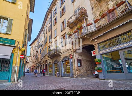 BERGAMO, ITALIEN - 7. APRIL 2022: Die alten Häuser an der historischen engen Via Gombito mit Cafés, Bäckereien, Pizzerias und Geschäften, Citta Alta, Bergamo, Ital Stockfoto