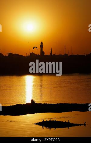 Mossul, Irak. August 2024. Allgemeiner Blick auf den Sonnenuntergang hinter dem Minarett der Imam-Mohsen-Moschee in der Stadt Mossul im Nordirak. (Foto: Ismael Adnan/SOPA Images/SIPA USA) Credit: SIPA USA/Alamy Live News Stockfoto