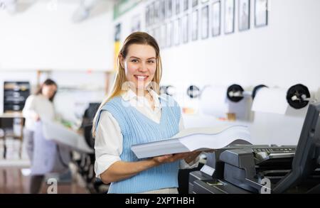 Der Techniker wechselt das Papier auf der Plottermaschine des Druckers Stockfoto