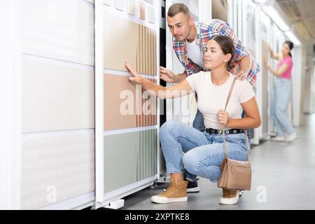 Ein paar Männer und Frauen wählen Kacheln im Laden Stockfoto