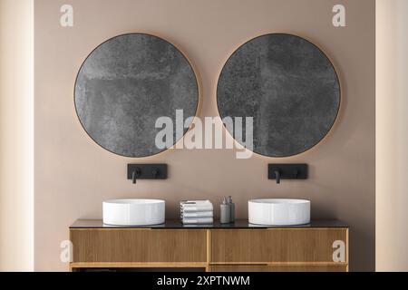 Nahaufnahme von Doppelwaschbecken mit ovalen Spiegeln auf beigefarbener Wand, Holzschrank mit schwarzen Armaturen im minimalistischen Badezimmer Stockfoto