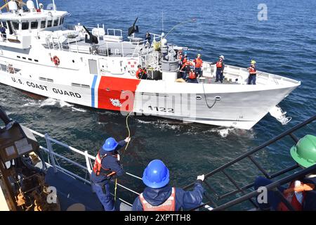 Petty Officer 2nd Class Warren Gardner, ein Bootsgefährte an Bord der U.S. Coast Guard Cutter Kimball (WMSL 765), wirft eine Heaving Line vom Kimball zum USCGC Bailey Barco (WPC-1122) während der First Eastern Fueling at Sea (AFAS) Evolution zwischen einem nationalen Sicherheitsschneider und einem Schnellreaktionsschneider in der Beringsee, 2. Juli 2024. Die AFAS verlängerte die Lebensdauer der Bailey Barco und führte dazu, dass die Mannschaft von Bailey Barco mehr als zehn Schiffe in Bristol Bay, Alaska, einem Gebiet, das von FRCS aufgrund logistischer Einschränkungen nicht routinemäßig erreicht wird. Foto der US-Küstenwache von Cadet Madison Whitw Stockfoto