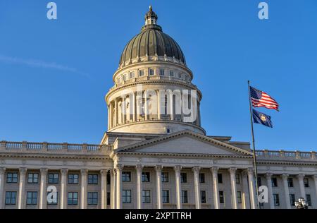 Utah State Capitol – Nahansicht der Kuppel und Fassade des Utah State Capitol Building, mit nationalen und staatlichen Flaggen im Vorfeld, Salt Lake City, UT. Stockfoto