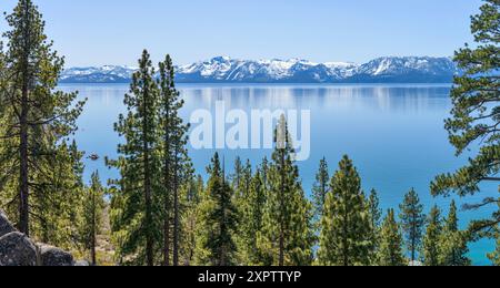 Blue Mountain Lake - Ein sonniger Blick auf den ruhigen blauen Lake Tahoe, umgeben von schneebedeckten Gipfeln und dichten Kiefernwäldern, Kalifornien-Nevada, USA. Stockfoto