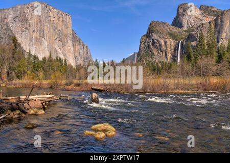 Merced River im Yosemite Valley - Blick auf den Merced River, der im Yosemite Valley verläuft, mit den El Capitan und den Bridalveil Falls, die sich am Ufer erheben. Stockfoto