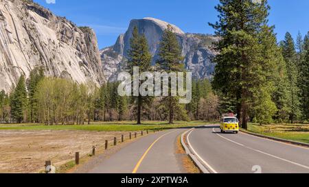 Reisen in Yosemite - Ein gelber klassischer Volkswagen Camper-Van auf der Yosemite Valley Loop Road, an einem sonnigen Frühlingstag im Yosemite National Park. Stockfoto