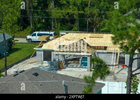 Luftaufnahme von Bauunternehmern, die an einem unfertigen Wohnhaus mit Holzdachrahmen arbeiten, der im Vorstadtbereich Floridas im Bau ist Stockfoto