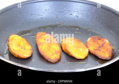 Maduros fritos oder gebratene süße Kochbananen, süß und fast wie ein Dessert, köstliche Lebensmittelzutat. Auf einer Küchenpfanne gemacht. Stockfoto