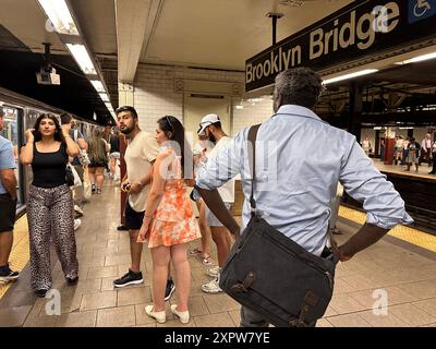 Die NYC U-Bahn-Fahrer warten am Ende des Tages an der Brooklyn Bridge U-Bahn-Station auf ihre Züge Stockfoto