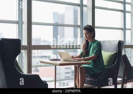 Asiatische Geschäftsfrau, die Hot Desking machte und mit der Arbeit beschäftigt war Stockfoto