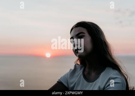 Silhouette einer jungen Frau bei Sonnenuntergang Stockfoto