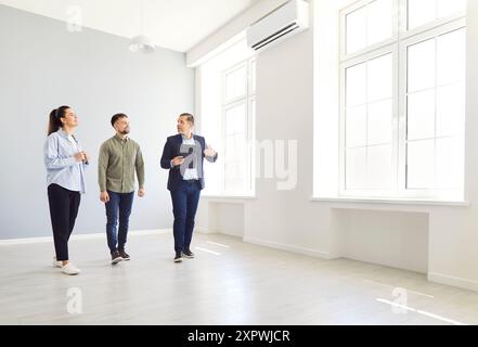 Mann und Frau reden mit Mann Makler in einem neuen Haus und bereit, Hausbesitzer zu werden. Stockfoto