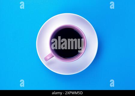 Ein isolierter schwarzer Kaffee auf hellrosa Jungtier auf blauem Hintergrund Stockfoto