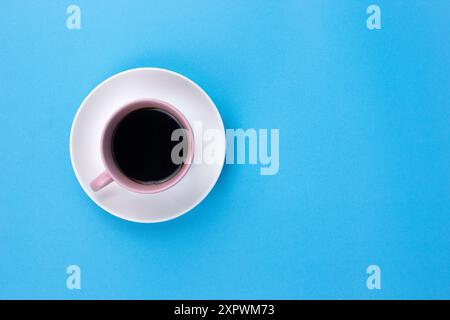 Ein isolierter schwarzer Kaffee auf hellrosa Jungtier auf hellblauem Hintergrund Stockfoto