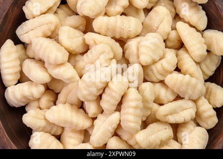 Ungekochte Kartoffelgnocchi-Knödel in Holzschüssel. Leckere rohe italienische Zutaten. Draufsicht Stockfoto