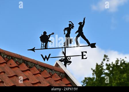 In Großbritannien: Dekorative Wetterfahne mit Gitarristen und Tänzern. Orford, Suffolk, Großbritannien Stockfoto