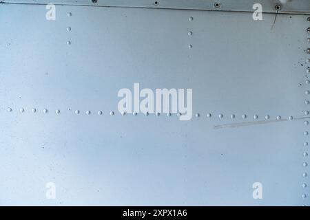 Hintergrund, Textur der Metallhaut eines Flugzeugs in Grau- oder Stahlfarbe mit Nieten. Hochwertige Abbildung Stockfoto