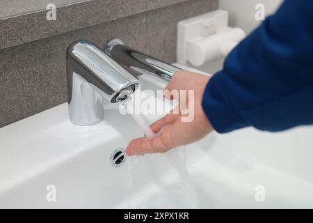 Nahaufnahme eines Mannes, der im Badezimmer die Hände wäscht Stockfoto
