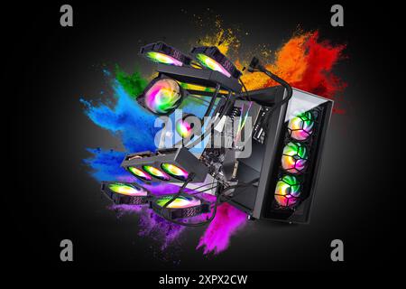 Schwarzer moderner High-End-Gaming-Computer mit Glasfenstern und hellen bunten Regenbogen-RGB-LED-Lichtern auf Regenbogenfarben-Explosionspuder-grauen Hintergrund. Stockfoto