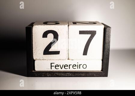 Eine Nahaufnahme eines hölzernen ewigen Kalenders, der den 27. Februar auf Portugiesisch zeigt. Stockfoto