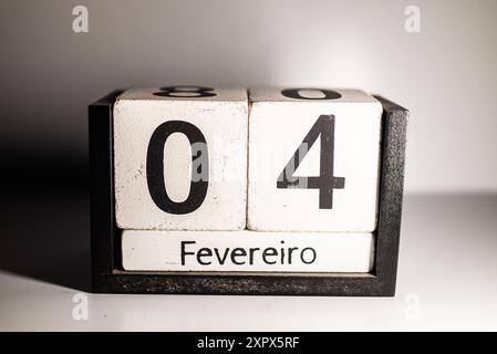 Eine Nahaufnahme eines hölzernen Kalenders, der den 4. Februar auf Portugiesisch zeigt. Stockfoto
