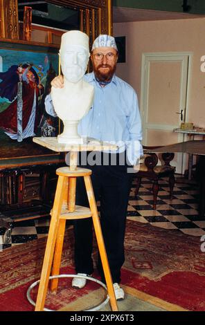 Ernst Fuchs, alias Professor Ernst Fuchs, berühmter Maler, Grafiker und Bildhauer aus Österreich, hier mit Büste als Selbst-Portrait in seinem Atelier, um 1990. Stockfoto