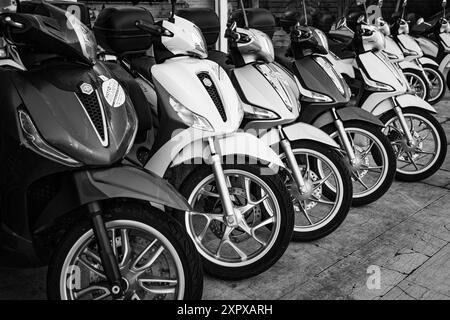 Motorräder zum Verleih oder Verkauf auf der Stadtstraße. Viele weiße Roller zum Fahren. Motorrad, Motorroller parken in Reihe in der Stadtstraße. Clos Stockfoto