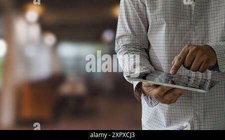 Geschäftsmann hält ein Modell. IPad Digital Tablet im Büro Multitasking im Internet Stockfoto