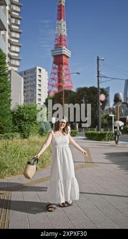 Fröhliche hispanische Frau in Brille, die mit offenen Armen die Atmosphäre der Stadt umgibt, strahlend über tokios Straßenleben lächelt und Schönheit und Freiheit in unserem verkörpert Stockfoto